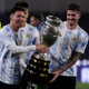 Argentina’s Lionel Messi (left) and Argentina’s Rodrigo De Paul (right) hold the Copa America trophy.